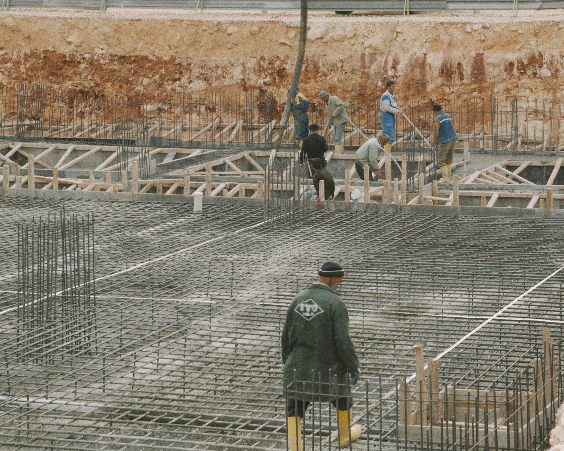 Helical piers being installed under a slab foundation
